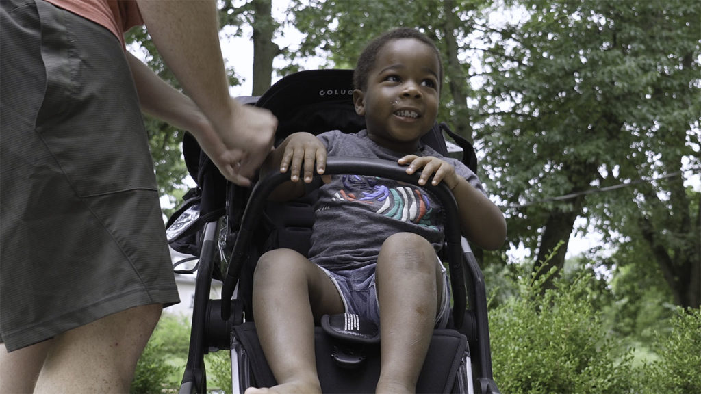 Picture of parent adjusting a child in the Colugo Complete stroller