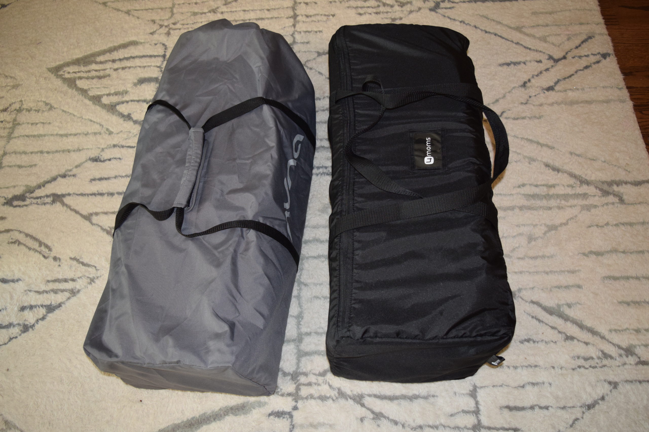 The Nuna Sena and the 4Moms Breeze Plus side by side on a carpet in their travel bags