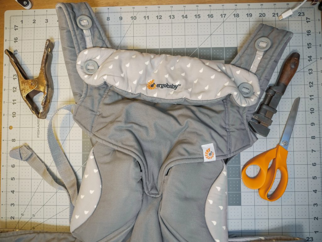 An Ergobaby 360 on a table with scissors